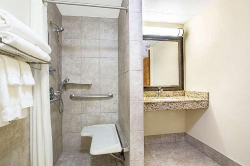 a bathroom with a shower and a toilet and a sink at AmericInn by Wyndham Green Bay West in Green Bay