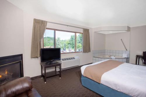a hotel room with a bed and a television at AmericInn by Wyndham Green Bay West in Green Bay