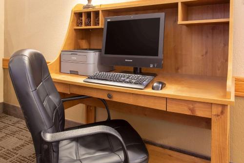 a desk with a computer monitor and a keyboard and mouse at AmericInn by Wyndham Calumet in Calumet