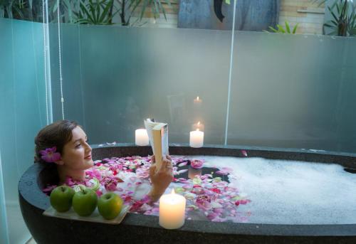 a woman in a bathtub with candles and flowers at Damrei Residence & Spa in Siem Reap