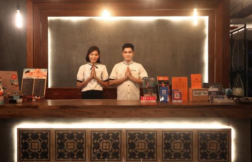 a man and a woman standing behind a counter with their hands at Central Corner d'Angkor in Siem Reap