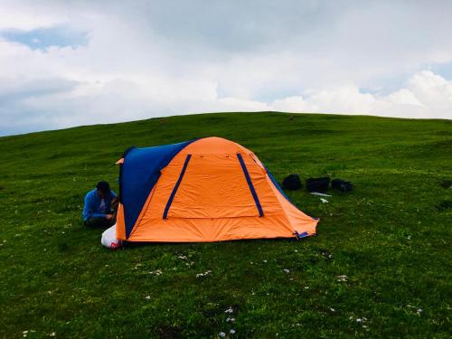 an orange and blue tent on a grassy field at Lantern Hotel in Hohhot