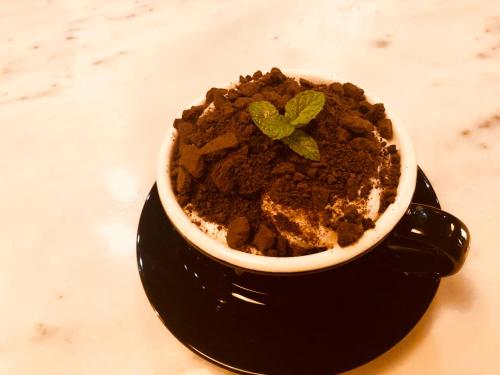 a cup of chocolate pudding with a green plant in it at Lantern Hotel in Hohhot