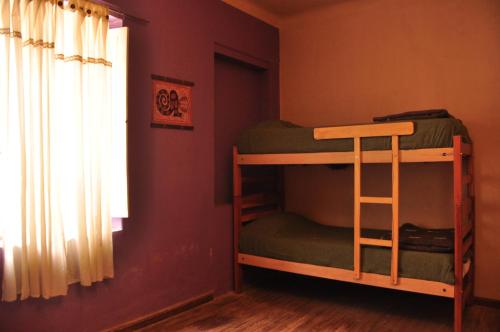a bedroom with bunk beds in a room with a window at Hostal La Antigua in Humahuaca