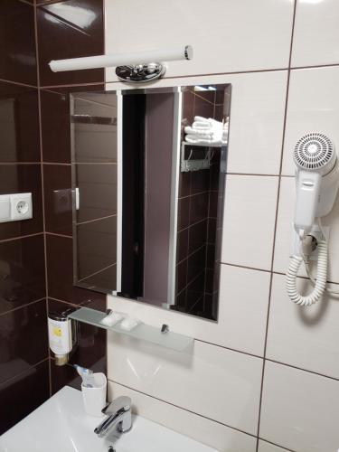 a bathroom with a mirror and a sink at Rhombus Hotel in Luts'k
