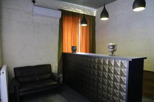 een bar met een leren stoel in een kamer bij Hotel AGUNA in Koetaisi