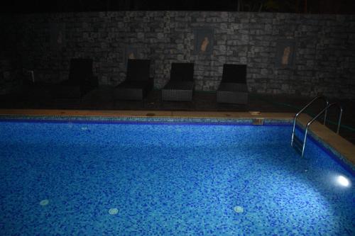 a large swimming pool with chairs in a room at Calangute Grande in Calangute