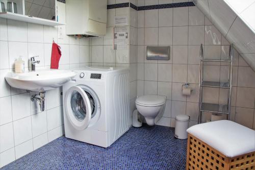 ein Badezimmer mit Waschmaschine und Waschbecken in der Unterkunft Waldhufenhaus in Schöna in Reinhardtsdorf