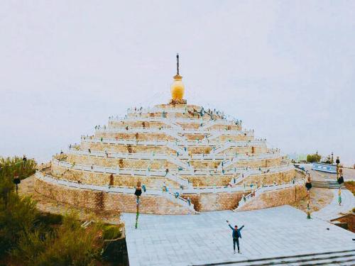 a man standing in front of a large pyramid at Lantern Hotel in Hohhot