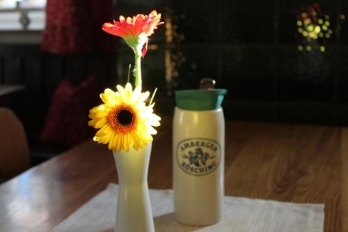 a vase with a flower and a bottle of milk at Hotel Brauereigasthof Amberger in Kösching