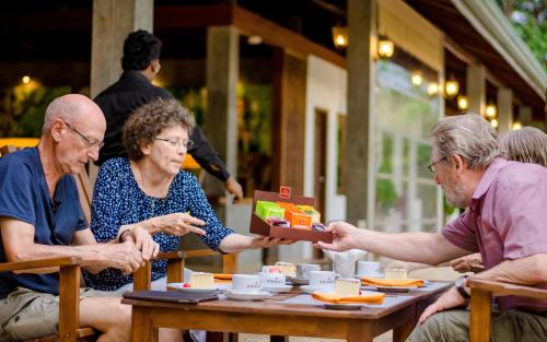 a group of people sitting at a table eating food at Amaara Forest Hotel Sigiriya in Sigiriya