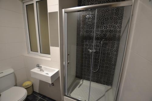 a bathroom with a shower and a sink at Valletta Dream Suites in Valletta