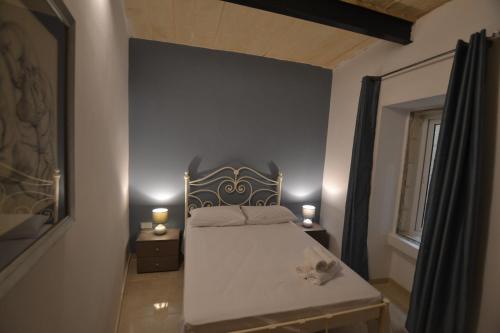 a bedroom with a bed and two lamps on tables at Valletta Dream Suites in Valletta