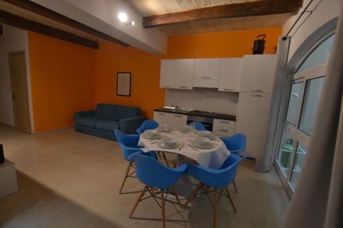 a kitchen with a table and blue chairs in a room at Valletta Dream Suites in Valletta