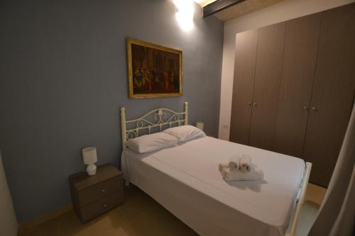 a bedroom with a white bed and a painting at Valletta Dream Suites in Valletta