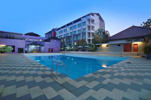 a swimming pool in front of a building at ASTON Tanjung City Hotel in Tanjung