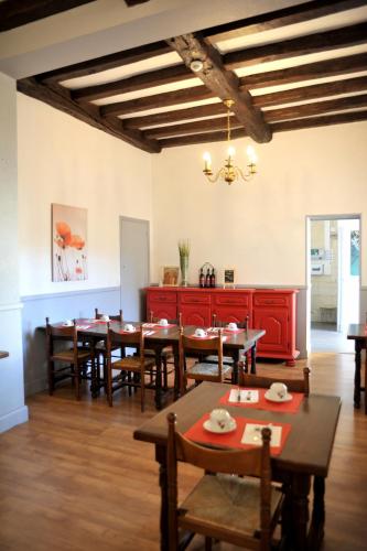a dining room with wooden tables and chairs at Grand Hôtel in Sainte-Foy-la-Grande
