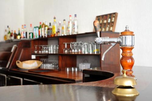 a bar with a wooden counter top with a drink dispenser at Grand Hôtel in Sainte-Foy-la-Grande