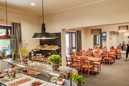 a restaurant with tables and chairs and a buffet at JUFA Hotel Maria Lankowitz in Maria Lankowitz