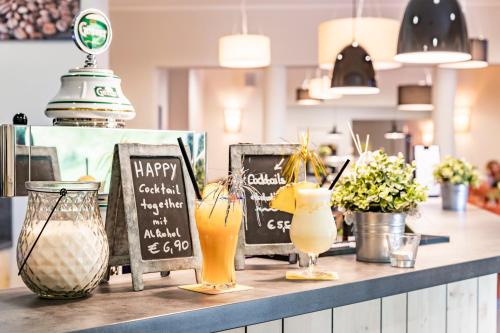 a bar with two drinks on a counter at JUFA Hotel Maria Lankowitz in Maria Lankowitz