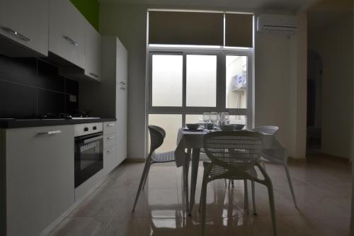 a kitchen with a table and chairs and a window at Valletta Dream Suites in Valletta