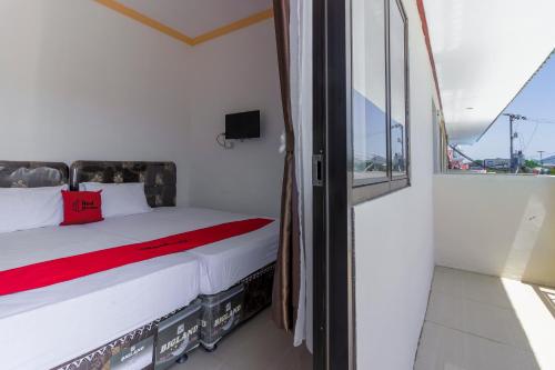une chambre avec un lit et une fenêtre dans l'établissement RedDoorz near Sam Ratulangi Airport Manado, à Manado