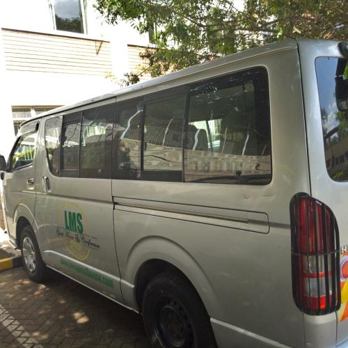 a white van parked in a parking lot at Adventist LMS Guest House & Conference Centre in Nairobi