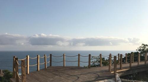 a wooden deck with a view of the ocean at Lelewatu Resort Sumba in Watukarere