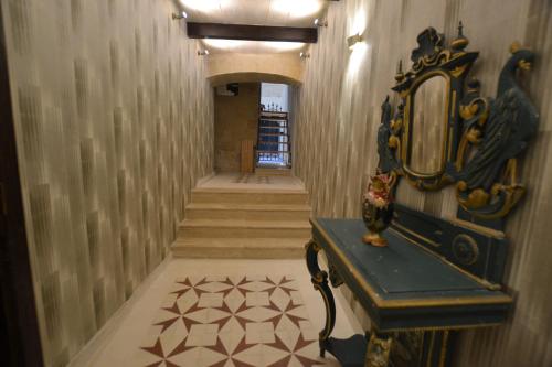 a hallway with a mirror and a table and stairs at Valletta Dream Suites in Valletta