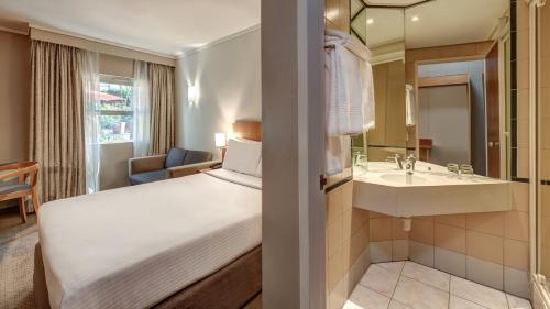 a hotel room with a bed and a sink at StayEasy Pretoria in Pretoria