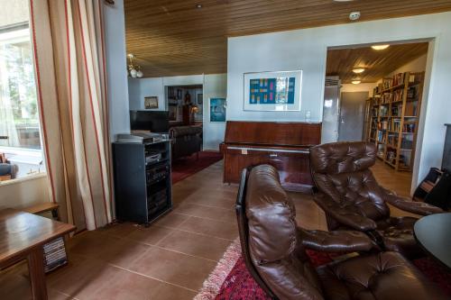 a living room with a desk and leather chairs at Villa Harald - Beachfront in Hitis