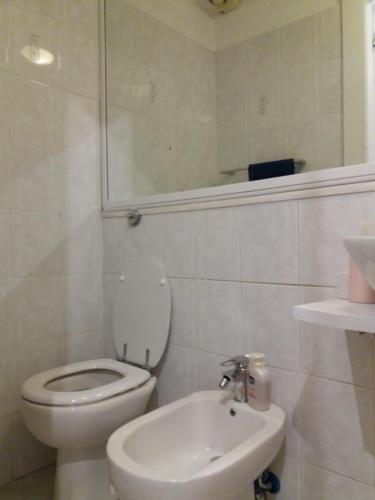 a white bathroom with a toilet and a sink at Casa Giulia in Cagliari