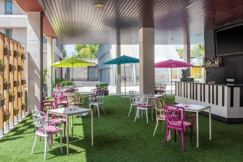 a restaurant with tables and chairs with umbrellas at Madrid Airport Suites, Affiliated by Meliá in Madrid