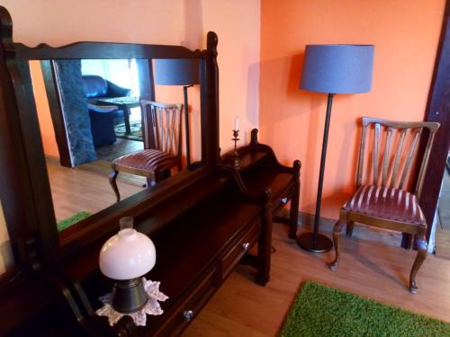a room with a mirror and two chairs and a lamp at Gospodarstwo u Krakusa in Doboszowice