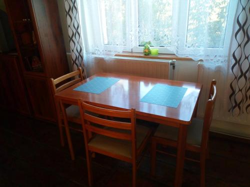 a wooden table with two chairs and a window at Gospodarstwo u Krakusa in Doboszowice