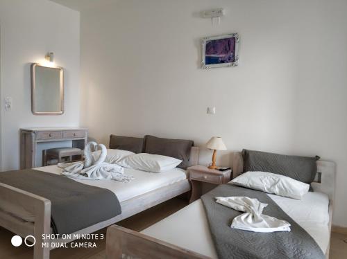 um quarto com duas camas, uma mesa e um espelho em Agapi Villas em Karterados
