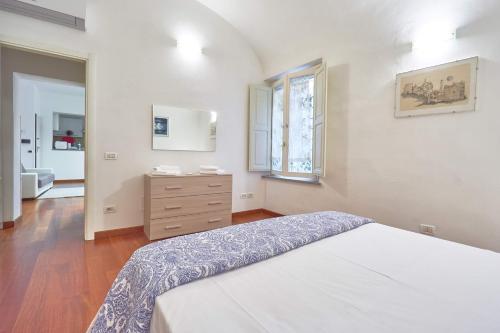 um quarto com uma cama, uma cómoda e uma janela em Il Silenzioso em Pisa