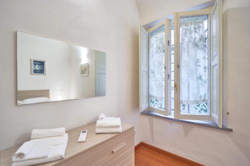 uma casa de banho com um espelho e uma janela em Il Silenzioso em Pisa
