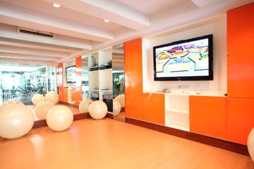 a room with orange walls and a flat screen tv at Amaranta Hotel in Bangkok