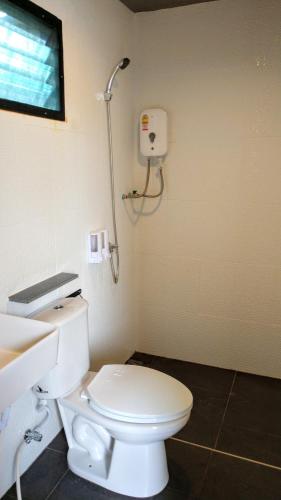 a bathroom with a white toilet and a sink at LAN LAY Resort (ลานเล รีสอร์ท) in Ban Mai Rut