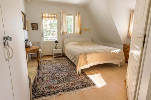 ein Schlafzimmer mit einem Bett, einem Teppich und einem Fenster in der Unterkunft Villa Harald - Beachfront in Hitis
