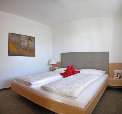 een slaapkamer met een groot bed met een rode bloem erop bij Landhaus Freiburgerhof in Rifiano