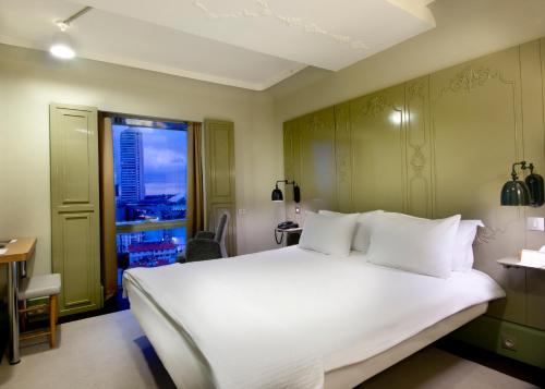 a bedroom with a large white bed and a window at The Marmara Sisli in Istanbul