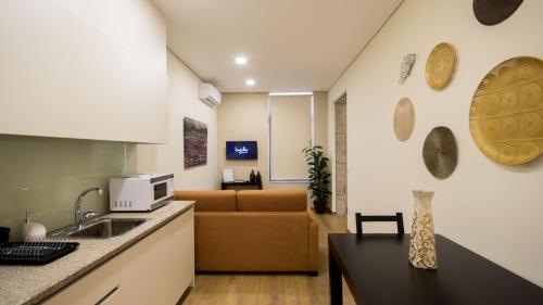 a kitchen and a living room with a couch at Bugalha My Loft Douro 8 in Peso da Régua