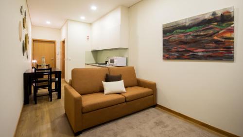 a living room with a couch and a painting on the wall at Bugalha My Loft Douro 8 in Peso da Régua