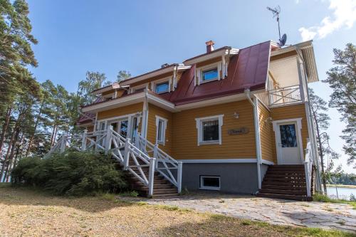 a yellow house with a red roof at Villa Harald - Beachfront in Hitis