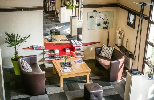 a room with two chairs and a table and a table sidx sidx at Hôtel Inn Design Resto Novo Chartres in Chartres
