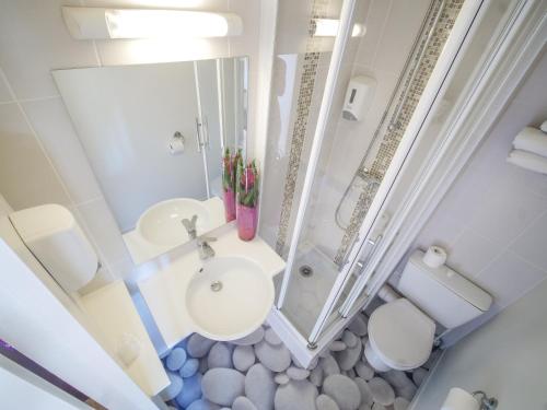 an overhead view of a bathroom with a toilet and sink at Hôtel Inn Design Resto Novo Chartres in Chartres