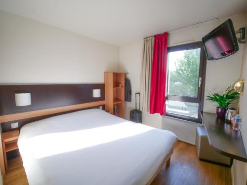 - une chambre avec un lit blanc et une fenêtre dans l'établissement Hôtel Inn Design Resto Novo Chartres, à Chartres