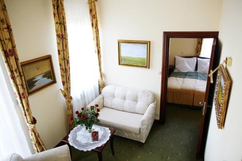 a living room with a chair and a bed at Hotel Villa Bohema in Kazimierz Dolny